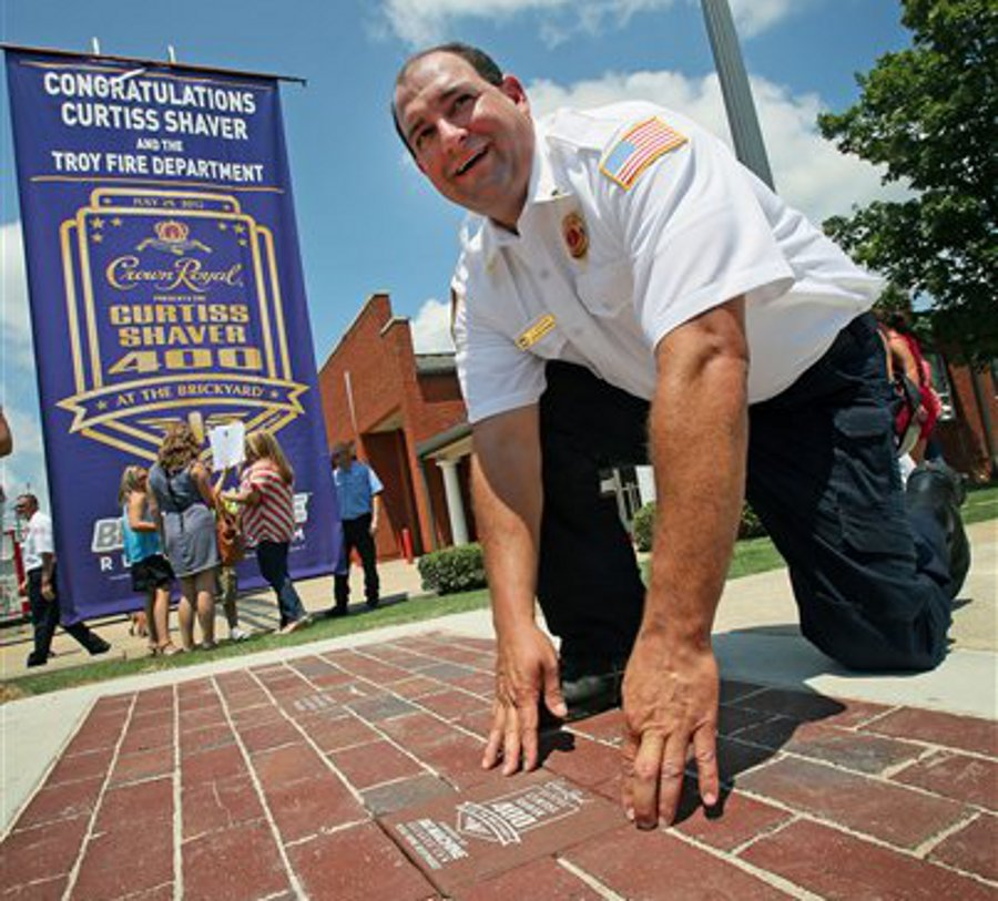 Troy Lt. Curtiss Shaver places the final brick in the ceremonial 'Yard of Bricks' outside of Station No. 1 on July 18.