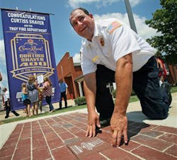 Troy Lt. Curtiss Shaver places the final brick in the ceremonial 'Yard of Bricks' outside of Station No. 1 on July 18. Troy Lt. Curtiss Shaver places the final brick in the ceremonial 'Yard of Bricks' outside of Station No. 1 on July 18.