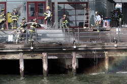 Firefighters work to extinguish a fire on Pier 17 at the South Street Seaport in New York on Saturday, July 14, 2012. Fire officials said there were no injuries.