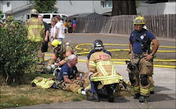 Paramedics tend to Forest Grove Capt. Joe Smith, who injured his leg trying to stop a man from running into a burning room, on Aug. 9. Paramedics tend to Forest Grove Capt. Joe Smith, who injured his leg trying to stop a man from running into a burning room, on Aug. 9.