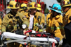 Los Angeles firefighters assist a child injured when a car sped onto a sidewalk and plowed into a group of parents and children outside an elementary schoolon Aug. 29.