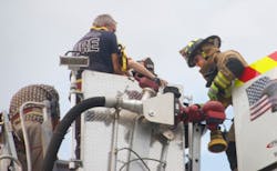 A firefighter from the Pascua Pueblo Fire Department, right, helps a victim from the bucket of a Green Valley ladder truck. A firefighter from the Pascua Pueblo Fire Department, right, helps a victim from the bucket of a Green Valley ladder truck.