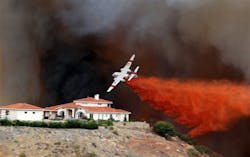 A firefighting air tanker drops fire retardant on a hillside as a wildfire rages on Aug. 1.