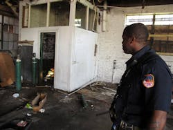 Camden Firefighter Asante Wilson looks at oxygen tanks in an abandoned building on Aug. 29.