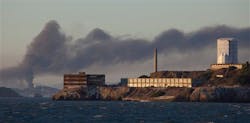 Smoke pours from a fire at the Chevron Richmond Refinery, seen behind Alcatraz Island in San Francisco, on Aug. 6.