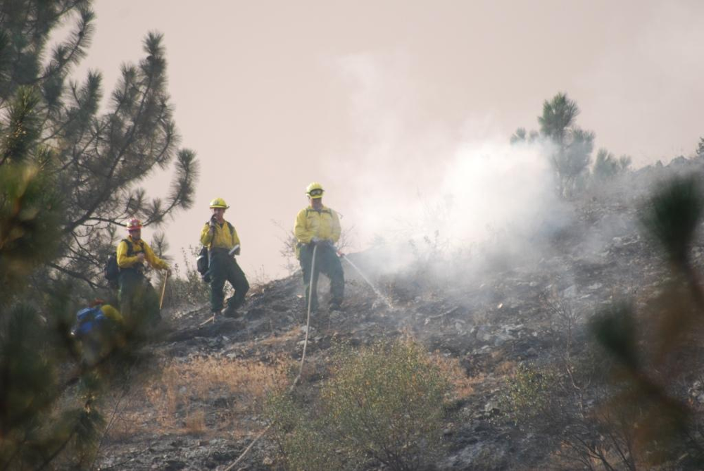 Firefighters douse hot spots from the Trinity Ridge Fire near Featherville, Idaho on Aug. 25.