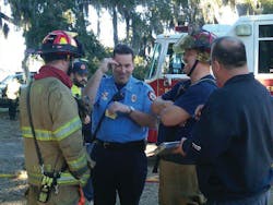 The author (center, blue shirt) shares with a crew how prevention efforts could have prevented the structure fire they just fought.