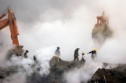 Firefighters make their way over the ruins and through clouds of smoke at the World Trade Center on Oct. 11, 2001.