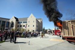 Flames shoot from the unsprinklered mock dorm room as firefighters prepare to knock the fire down. Flames shoot from the unsprinklered mock dorm room as firefighters prepare to knock the fire down.