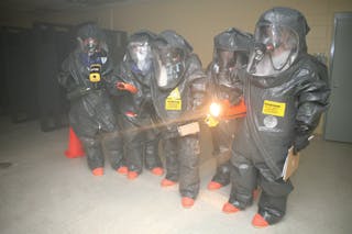 Responders prepare to enter a room and use devices that detect for the presence of chemical, biological, and radiological material during the revised 40-hour class in Anniston, AL.