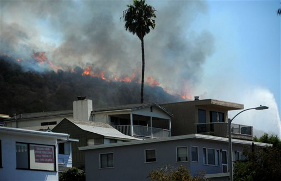A wildfire looms above homes near the Ruby's Diner on the Pacific Coast Highway in Laguna Beach, Calif. on Sept. 16.