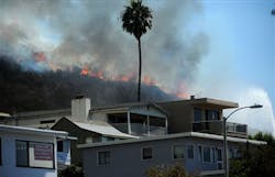 A wildfire looms above homes near the Ruby's Diner on the Pacific Coast Highway in Laguna Beach, Calif. on Sept. 16. A wildfire looms above homes near the Ruby's Diner on the Pacific Coast Highway in Laguna Beach, Calif. on Sept. 16.