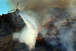 A helicopter executes a drop on a fast-moving fire along the 405 Freeway in Los Angeles on Sept. 14. A helicopter executes a drop on a fast-moving fire along the 405 Freeway in Los Angeles on Sept. 14.