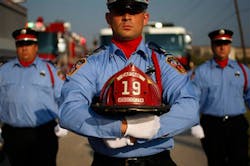 Holding the helmet of Atascocita Volunteer Fire Department Capt. Neal W. Smith, Lt. Joseph Cuccia and his fellow firefighters lead a procession on Sept. 24.