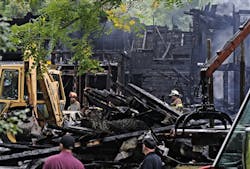 Firefighters search the scene of the fire in Uxbridge, Mass., for a missing woman and child on Sept. 4.