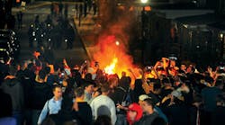 A crowd gathers around a fire set on Grant Avenue after the WVU football team&rsquo;s 48-45 victory over the University of Texas on Oct. 7 in Morgantown, W.Va.