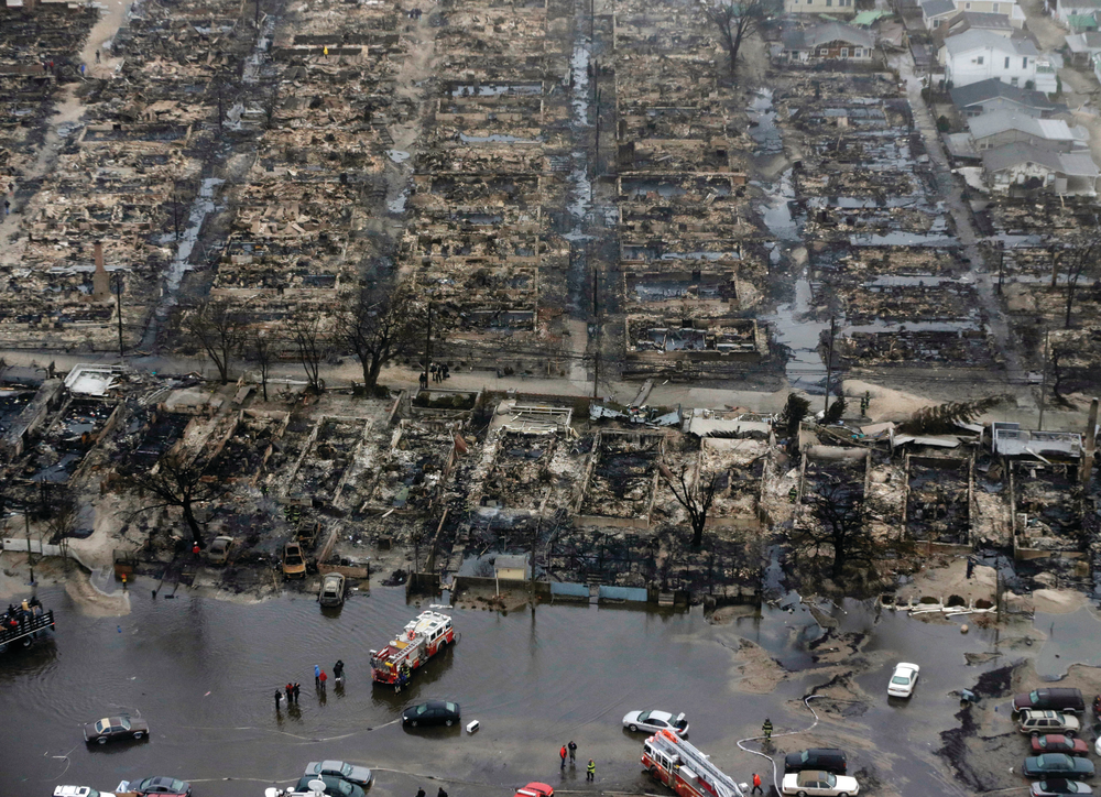 Aerial view shows the damage done to Breezy Point, NY, after an apparent downed power line sparked a wind-swept fire that involved 111 homes. The area, hit by a tornado earlier in the year, lies adjacent to the Atlantic Ocean. Several engine companies wound up drafting from the street.