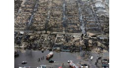Aerial view shows the damage done to Breezy Point, NY, after an apparent downed power line sparked a wind-swept fire that involved 111 homes. The area, hit by a tornado earlier in the year, lies adjacent to the Atlantic Ocean. Several engine companies wound up drafting from the street.