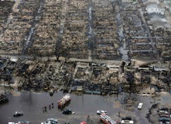 Aerial view shows the damage done to Breezy Point, NY, after an apparent downed power line sparked a wind-swept fire that involved 111 homes. The area, hit by a tornado earlier in the year, lies adjacent to the Atlantic Ocean. Several engine companies wound up drafting from the street.