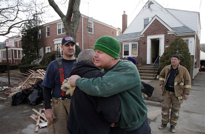 New York firefighter John Dwyer, facing camera, hugs New Orleans firefighter Robert Tourres, after a group of New Orleans firefighters assisted in the cleanup of the Dwyer family home, flooded in Superstorm Sandy, in the Belle Harbor section of Queens, N.Y., Wednesday, Nov. 28, 2012. New Orleans firefighters Bill Spiers, left, and Bruce Hurley, Sr. joined in the cleanup.