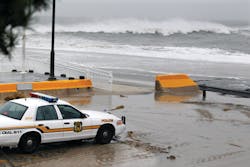 A police officer watches from his patrol car as the rough Atlantic Ocean threatens streets on Oct. 29 in Cape May, N.J. A police officer watches from his patrol car as the rough Atlantic Ocean threatens streets on Oct. 29 in Cape May, N.J.