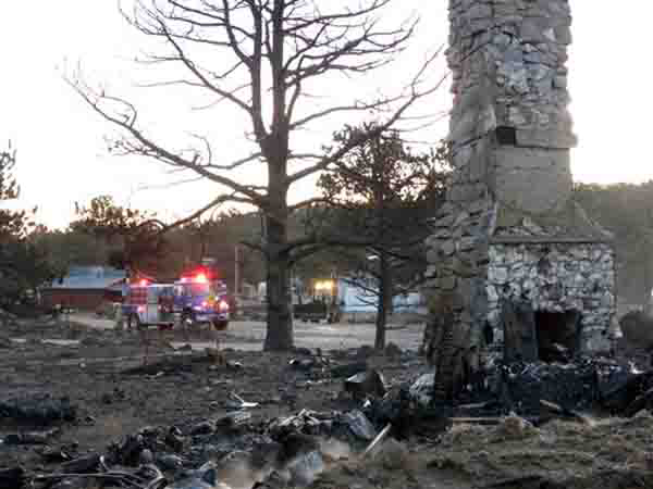 In this photo provided by the Poudre Fire Authority, firefighters battle a blaze at Red Feather Lakes in Estes Park, Colo., Monday, Dec. 3, 2012. The fire was quickly controlled, and residents were allowed to return.