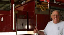 The late Jack Peltier, a former assistant chief with Marlbourgh (Mass.) Fire Department, poses with the fire engine he helped get donated to the Johnson County Rural Fire District No. 1, in Clarksville, Ark.