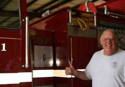 The late Jack Peltier, a former assistant chief with Marlbourgh (Mass.) Fire Department, poses with the fire engine he helped get donated to the Johnson County Rural Fire District No. 1, in Clarksville, Ark.