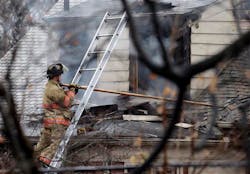 A firefighter works to extinguish a fire Tuesday, Dec. 18, 2012, in Shaker Heights, Ohio. Authorities say two people died in an overnight house fire in Shaker Heights, east of Cleveland. Assistant Fire Chief Wayne Johnson tells reporters that five other residents were rescued and taken to a hospital after the two-story home went up in flames.