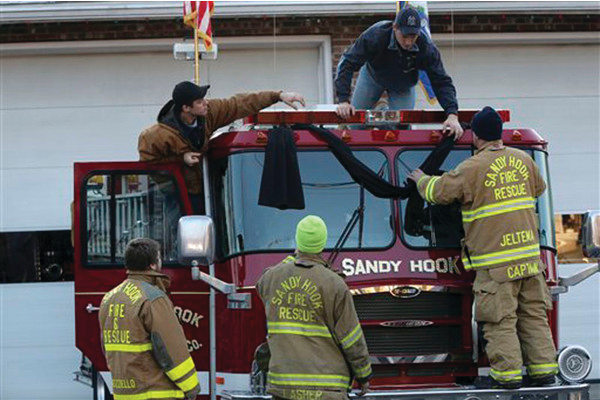 Sandy Hook firefighters hang bunting on their firetruck in the Sandy Hook village of Newtown, Conn. following the school shooting.