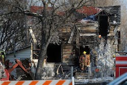 A Sioux Falls firefighter exits the remains of the home at Brookings and Main Ave. in northern Sioux Falls, S.D. on Saturday, Dec. 22, 2012. A fire that tore through a home in Sioux Falls on Saturday morning killed three children and sent two adults to the hospital, leaving a neighborhood in mourning just days before Christmas.