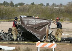 Casa Grande Firefighters cover the bodies of two victims of a plane crash Wednesday Feb. 6, 2013 at Casa Grande Municipal Airport in Casa Grande, Ariz. Federal Aviation Administration officials say the twin-engine turbo prop went down at 11:35 a.m. Wednesday as it was landing and the craft was destroyed by fire. FAA spokesman Ian Gregor says the cause of the crash is unclear. He says an FAA investigator is en route to the scene. Casa Grande police and fire officials didn&apos;t immediately release the names of the two killed.