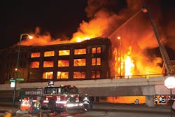 Apparatus is positioned away from the building as the fire spreads to the upper floors. Apparatus is positioned away from the building as the fire spreads to the upper floors.