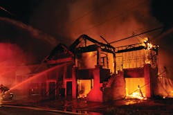 Firefighters in New Orleans, LA, battle a four-alarm fire that destroyed a pair of vacant two-story, wood-constructed dwellings. One of the homes totally collapsed.