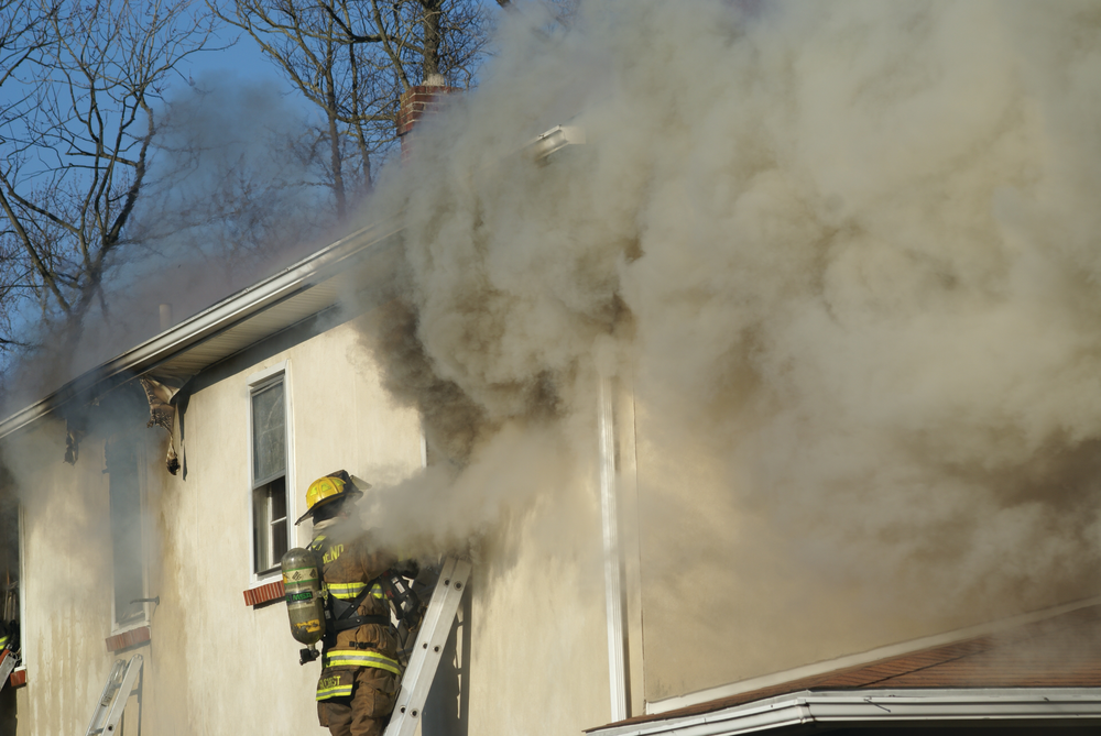 Photo 1. Turbulent smoke vents out the window where firefighters had been searching for fire extension.