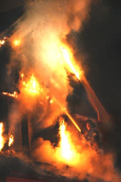 A Detroit firefighter works a stream from 1-1/2-inch hoseline at a dwelling fire. A Detroit firefighter works a stream from 1-1/2-inch hoseline at a dwelling fire.