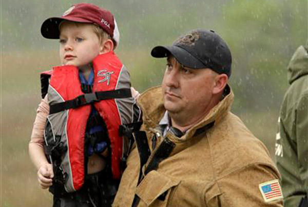 Miami-Dade Fire Rescue firefighter Jeff Hackman carries Zane Schreck, 4, to be checked out by paramedics at Everglades Francis S. Taylor Wildlife Management Area in Miami-Dade County, Friday, April 5, 2013. The Schreck family, from Ohio, spent a rainy, anxious night in the vast Florida Everglades when their airboat became stuck in vegetation so thick rescuers could not see them from the ground. The Schrecks were found safe Friday when searchers heard them blowing whistles and an air horn. The father, an avid outdoorsman, said he simply took a wrong turn and got stuck.