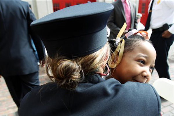 Rosalyn Weeks, 7, gets a huge hug from firefighter/paramedic Natalie Thomas following a ceremony in which Weeks was recognized by the Memphis Fire Department Tuesday, April 16, 2013, for her actions that saved her dad's life when he collapsed after his heart stopped beating due to congestive heart failure in September 2012. Thomas was one of the first responders from Engine 29 that made the scene after Weeks' quick thinking.