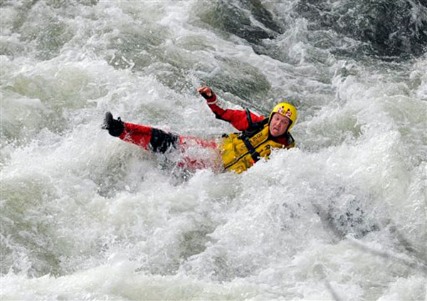 A Bowling Green, Ky., firefighter careens through the rapids of the Barren River, Monday, April 1, 2013 after trying to assist in the rescue of two teenage fishermen that were stranded in the rapids after their boat overturned. The fishermen were rescued after two hours and the firefighter was transported to the Medical Center with unknown injuries.