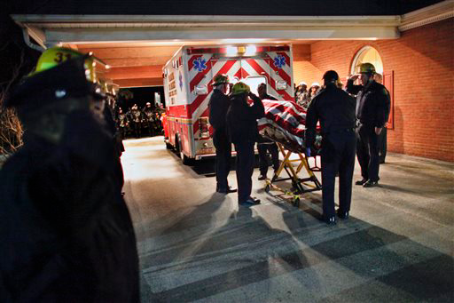 Responders salute as the body of their captain is removed from an ambulance at the hospital.
