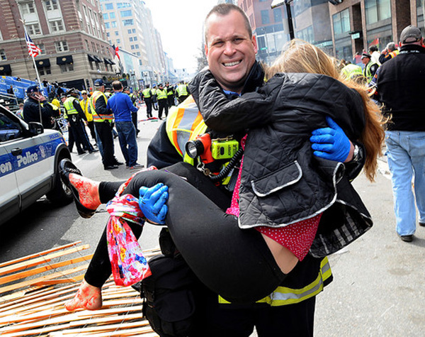 Boston Firefighter James Plourde carries an injured girl away from the scene after a bombing near the finish line.