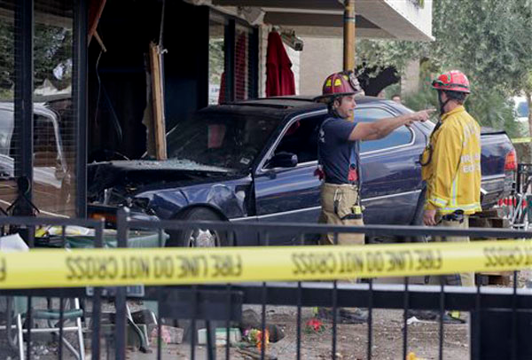 Las Vegas firefighters examine the scene of an accident where a vehicle crashed into a crowded restaurant, Monday, April 1, 2013, in Las Vegas. Ten people were seriously injured and at least one person was arrested Monday after the car plowed into the patio of the Egg & I restaurant during the lunch hour and came to rest with its hood inside a shattered plate glass window. Victims were transported to two nearby hospitals with non-life threatening injuries after the crash shortly after 12:30 p.m.