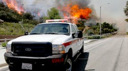 A Ventura County Firefighter drives near a hotspot as smoke andfire billows over a hill near Thousand Oaks, Calif. on Thursday, May 2, 2013. Authorities have ordered evacuations of a neighborhood and a university about 50 miles west of Los Angeles where a wildfire is raging close to subdivisions. AP Photo/Nick Ut
