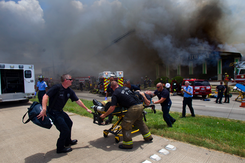 A firefighter is wheeled to an ambulance after fighting a fire at the Southwest Inn, Friday, May 31, 2013, in Houston.