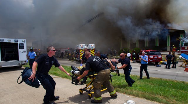 A firefighter is wheeled to an ambulance after fighting a fire at the Southwest Inn, Friday, May 31, 2013, in Houston.