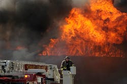 A firefighter from the Howard Fire Department operates a ladder truck as flames rip through the roof to the Northern Pines apartment complex in Howard, Wis. A firefighter from the Howard Fire Department operates a ladder truck as flames rip through the roof to the Northern Pines apartment complex in Howard, Wis.