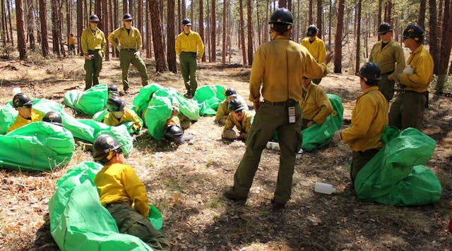 In this 2012 photo provided by the Cronkite News, Phillip Maldonado, a squad leader with the Granite Mountain Hotshots, trains crew members on setting up emergency fire shelters