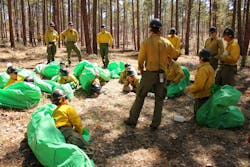 In this 2012 photo provided by the Cronkite News, Phillip Maldonado, a squad leader with the Granite Mountain Hotshots, trains crew members on setting up emergency fire shelters