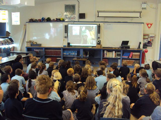 A packed classroom watches on as Dayna Hilton and her fire safety dogs share fire prevention messages via Skype.