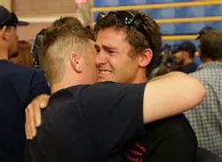 Firefighters console one another during a vigil Monday night. Firefighters console one another during a vigil Monday night.